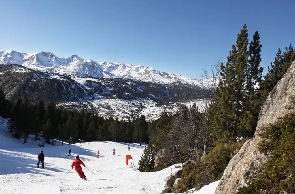 Des skieurs décendent une pente à la station pyréenées 2000
